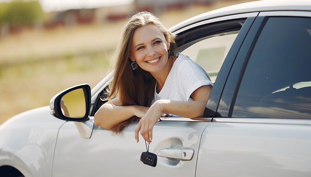 woman smiling out of a car window