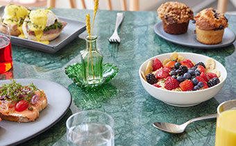 table with berries, muffins, eggs benedict, toast and juice